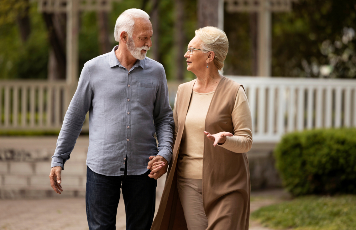 Zwei ältere Menschen sprechen miteinander beim laufen